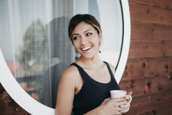 A Smiling Woman In Her First Trimester Of Pregnancy