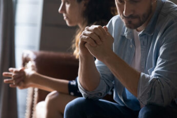 A Concerned Woman And A Concerned New Father Sitting Together