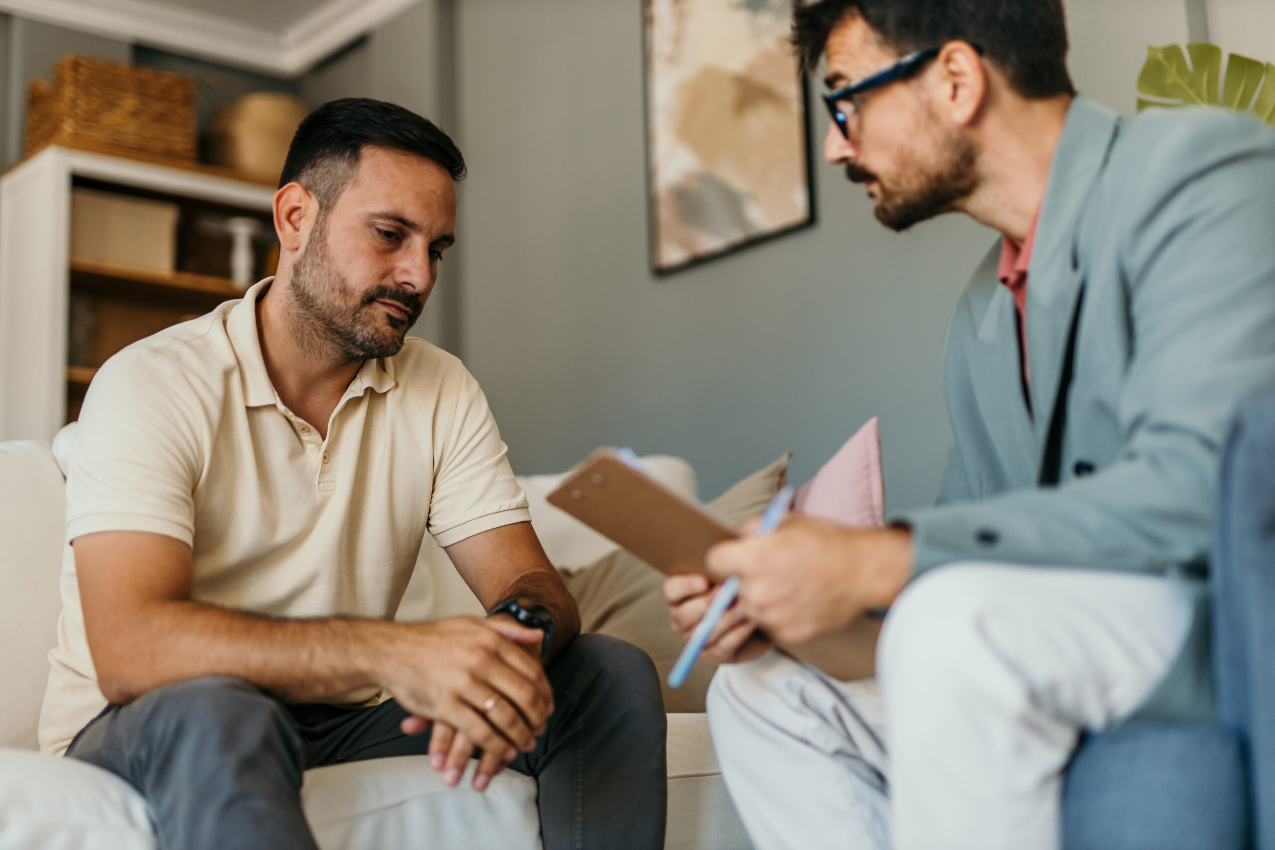 A scared man in a counseling session talking with a counselor
