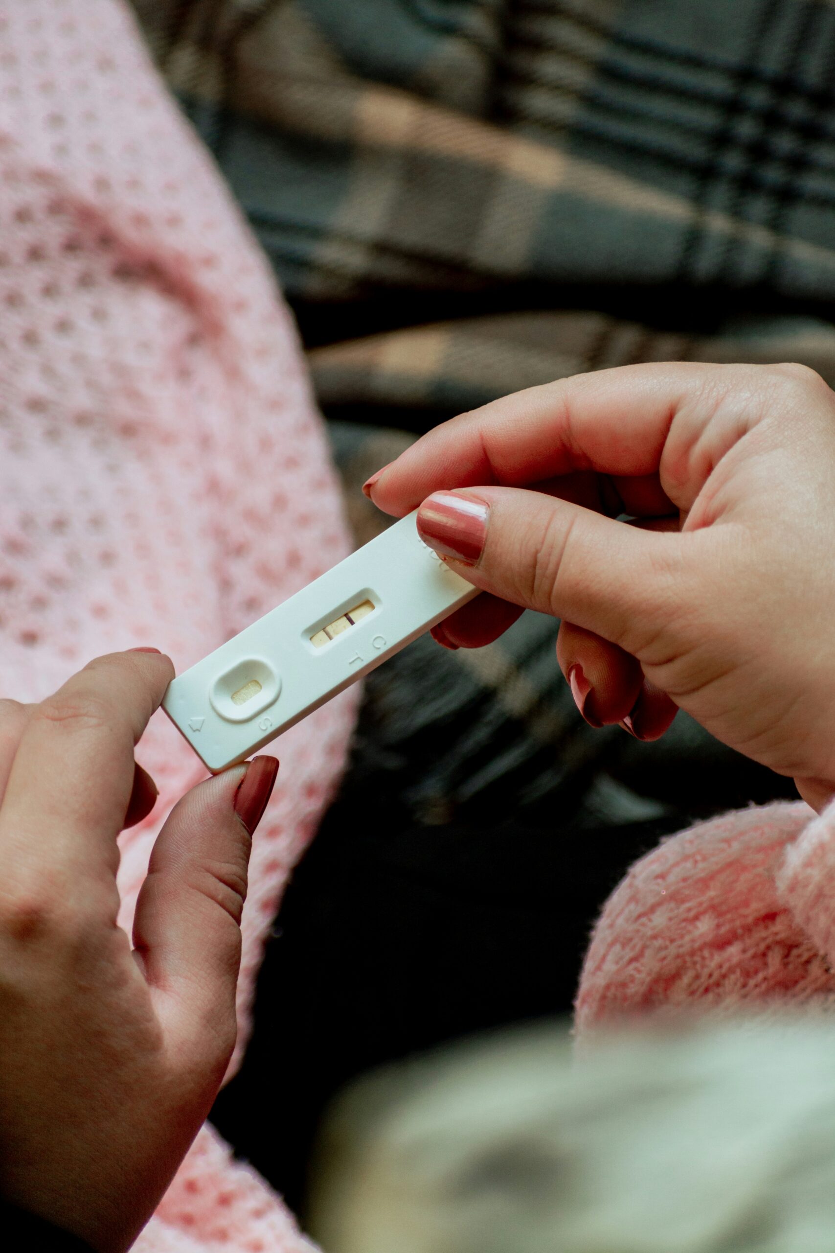 Older woman holding positive pregnancy test