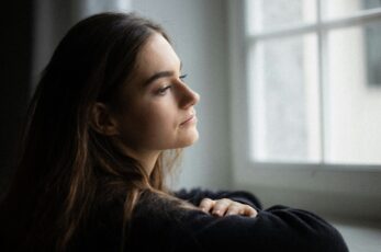 Pregnant Woman Looking Out Window Considering Her Pregnancy Options
